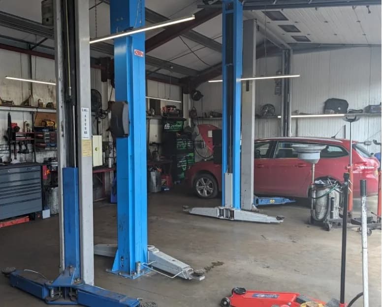 Inside the Dellers workshop — two-post lifts, with a car in for work behind them